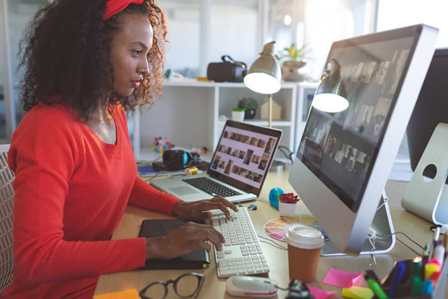 a woman looking at social media branding images on her desktop and laptop