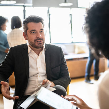 A man and a woman discussing the business growth consulting strategy recommendation of focusing on talent acquisition