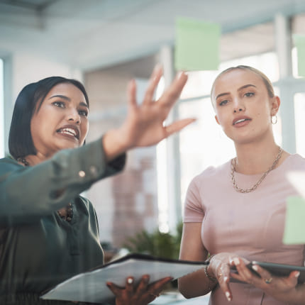 Two women discussing the business growth consulting strategy recommendation of highlighting value proposition