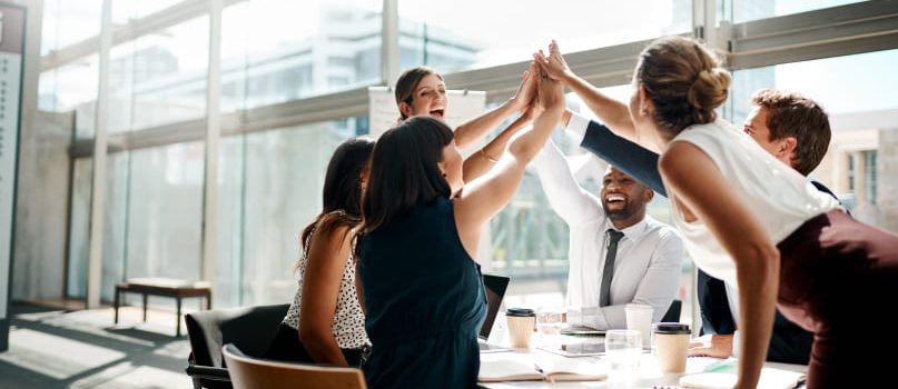 A group of New York eCommerce development company experts high-fiving a successful launch