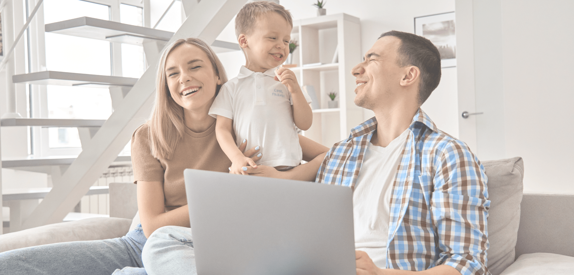 A family laugh by a laptop