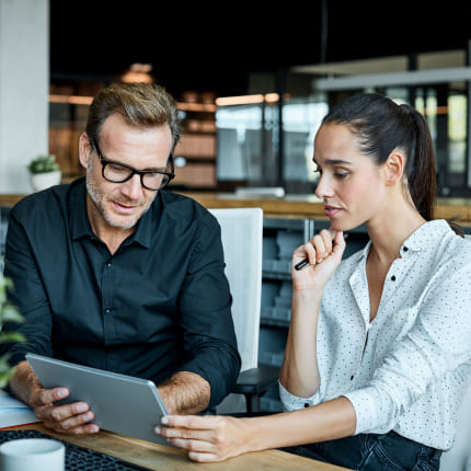 Colleagues look at tablet in the office together