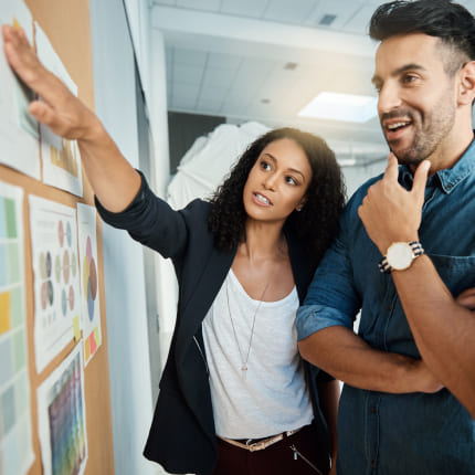 Two workers strategize on a board