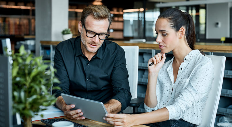 A Pittsburgh brand strategist showing a B2B client design concepts on an iPad