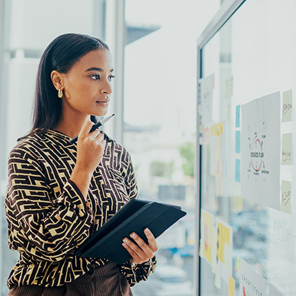 a woman looking at a white board