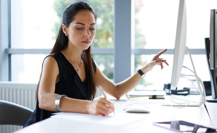 LA logo designer working at her desk taking notes