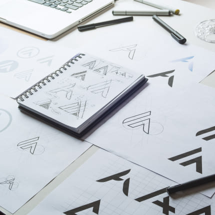 Logo designs on paper at a graphic design company in NYC