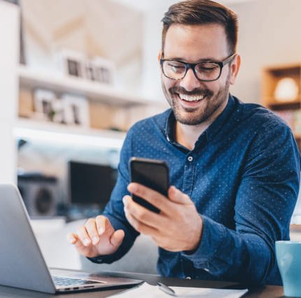 man smiling while looking at gym website on mobile