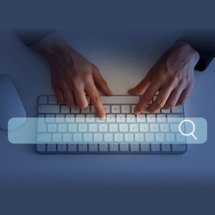 A pair of hands typing on a keyboard