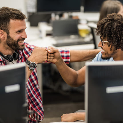 two people smiling at computer, symbolizing customer trust