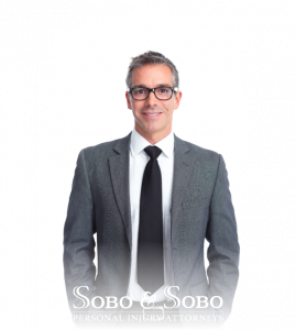 A man in a suit and glasses smiles at the camera for Sobo & Sobo's lifestyle image