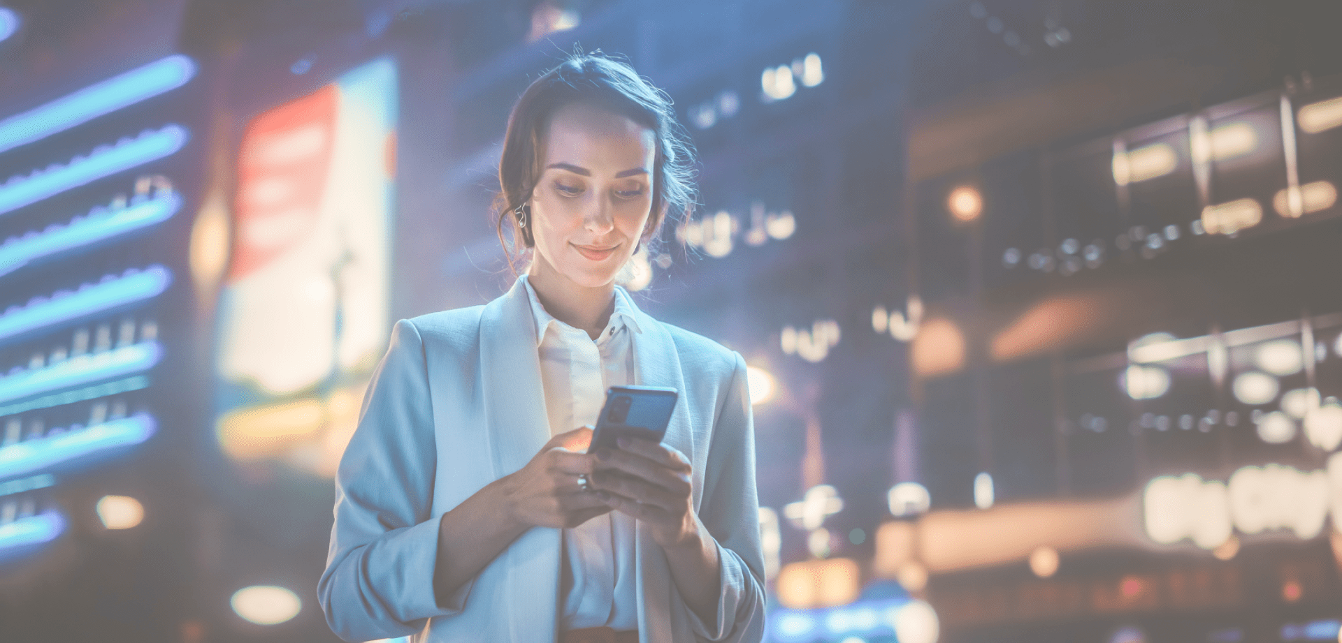 A woman checks her phone in an urban setting