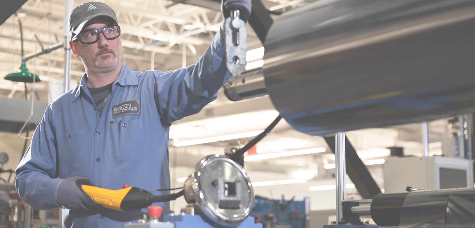 boston-materials-backgorund-1 Background image for Boston Materials' case study showing an employee working with industrial equipment in a manufacturing facility