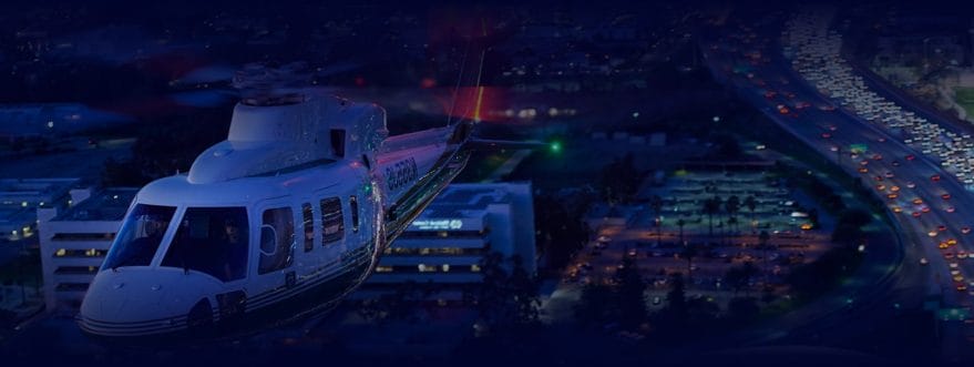 Background image for Helinet Aviation's case study showing a helicopter flying above a city at night