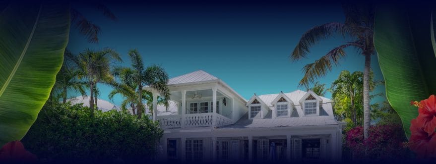 vhokw-background-2 Background image for Vacation Homes Of Key West's case study showing a tropical white house with palm trees and flowers