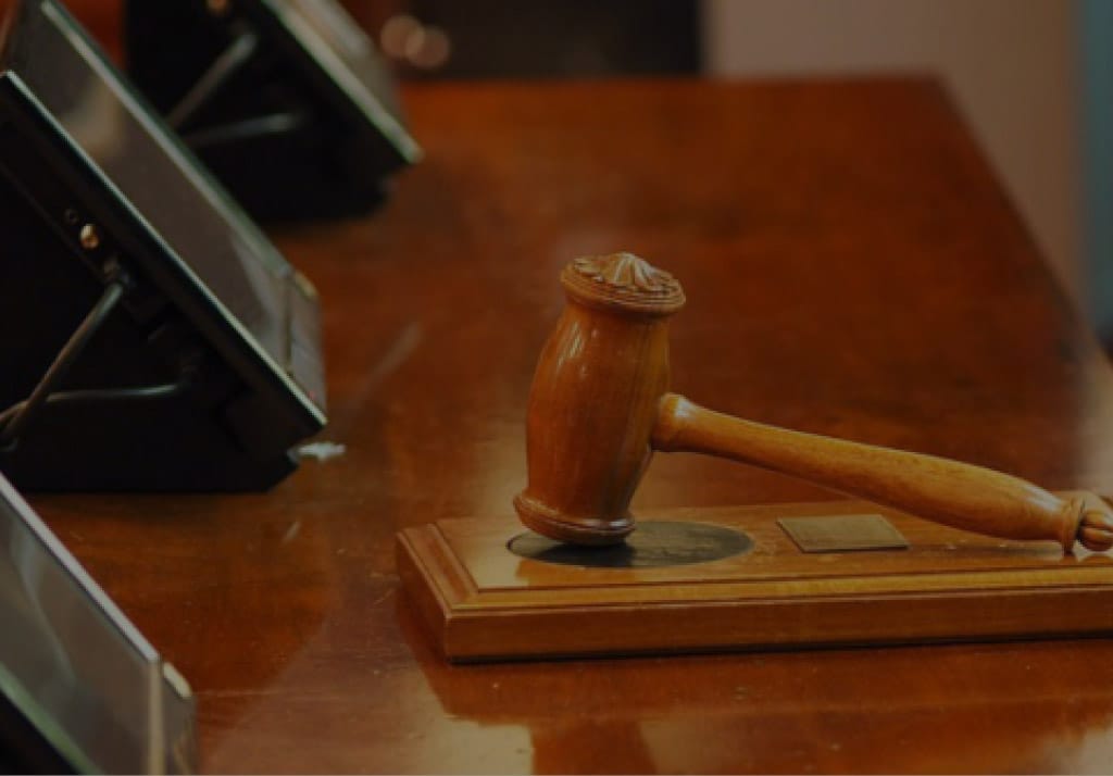 Wooden judge’s gavel resting on a sound block on a polished courtroom table