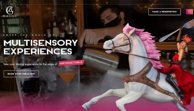 custom-web-development-services-barton-g-homepage Barton G. homepage layering a white carousel horse and costumed performer over a cocktail bar scene with bold Multisensory Experiences headline and reservation button.