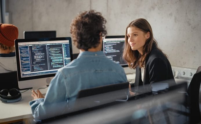 SEO specialists reviewing technical website data and search performance on desktop monitors during a strategy session