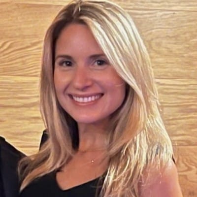 SaaS Marketing 63 Smiling blonde woman in a black top standing in front of a wood-paneled background