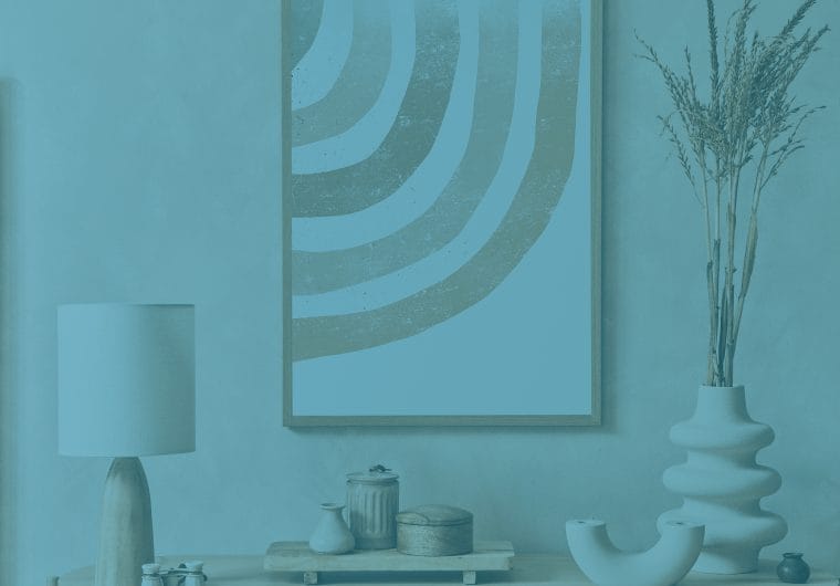 Blue-toned interior scene with a table lamp, abstract wall art, decorative vases, and dried branches