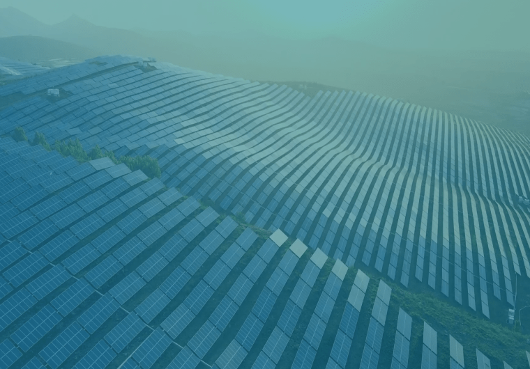 Aerial view of a large solar farm spread across rolling hills