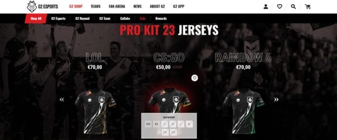 G2 Esports shop page showing the Pro Kit 23 Jerseys collection with LOL, CS:GO and Rainbow 6 team jerseys displayed against a dramatic crowd photography background, with a quickshop size selector overlay