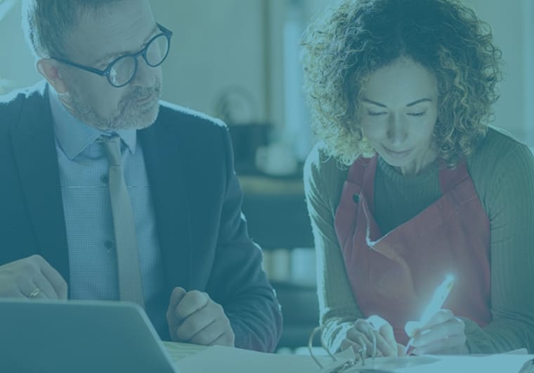 Business meeting with two people reviewing documents at a table