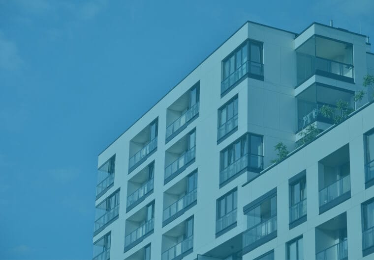 Corner view of a modern multi-story apartment building with balconies and large windows