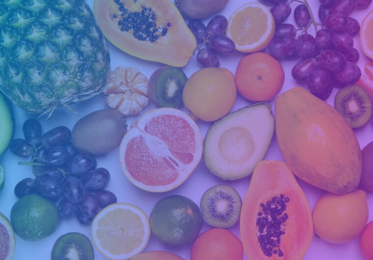 Assortment of fresh fruit spread out on a white surface