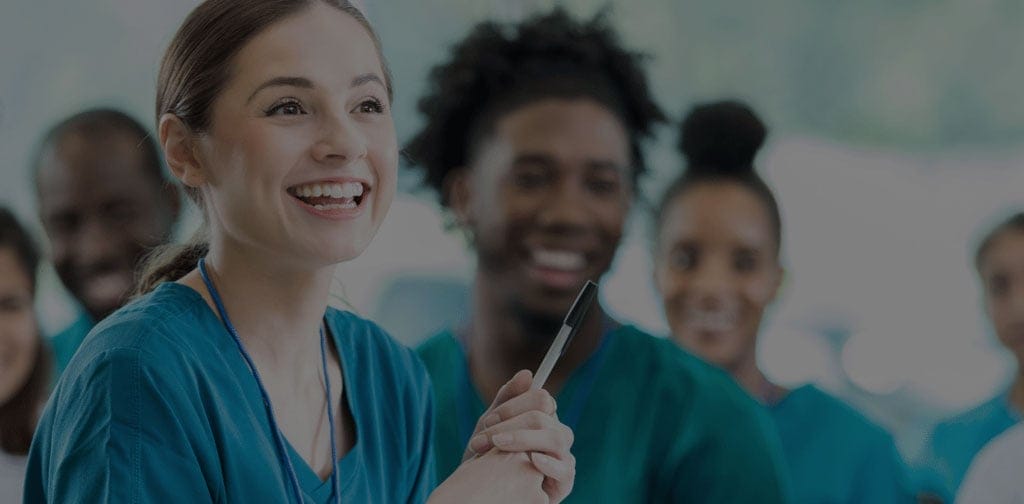 Smiling healthcare professionals in scrubs.