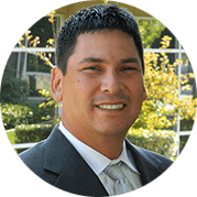 Home Page - NEW 297 Headshot of a man in a suit and tie smiling outdoors